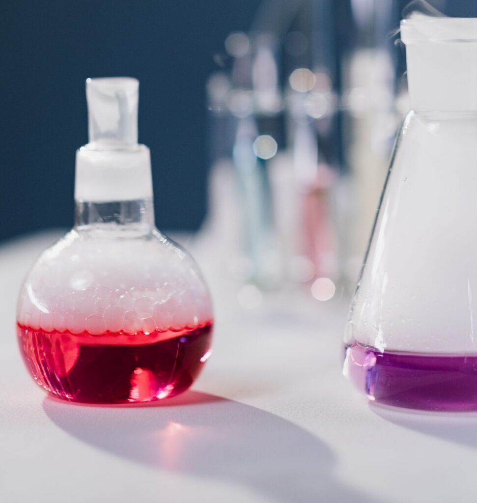 Close-up view of flasks with colorful reactions in a laboratory setting.